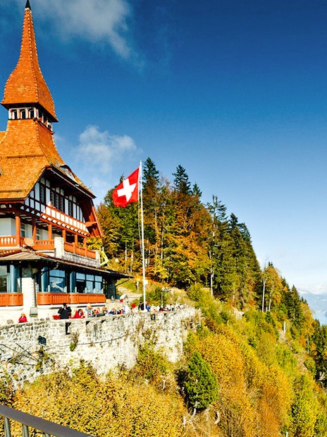 Harder Kulm viewpoint with Swiss flag, overlooking Lake Brienz and the Alps.