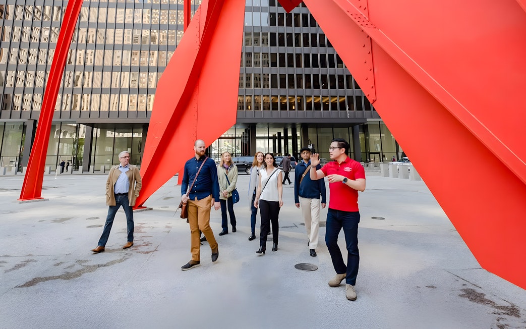 Guided group walking under Calder's Flamingo sculpture in Chicago.