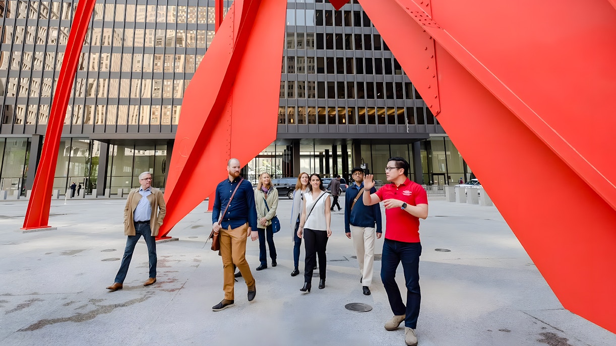 Guided group walking under Calder's Flamingo sculpture in Chicago.