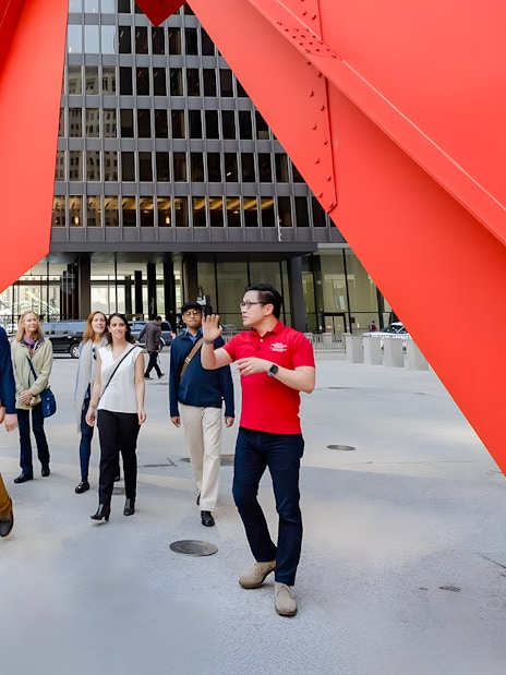 Guided group walking under Calder's Flamingo sculpture in Chicago.