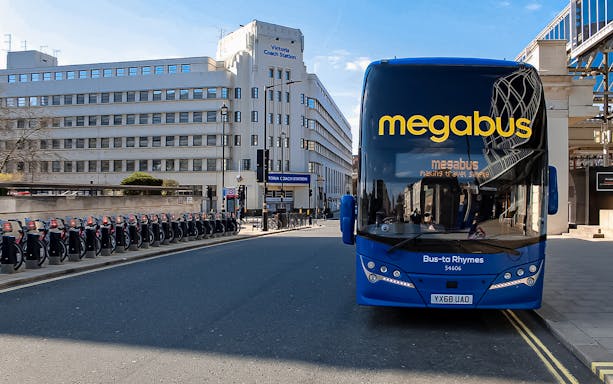 Megabus parked in front of Victoria Coach Station, London, for airport transfer service.