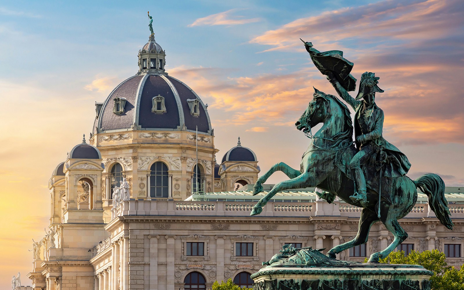 Equestrian statue in front of Vienna's Kunsthistorisches Museum at sunset.