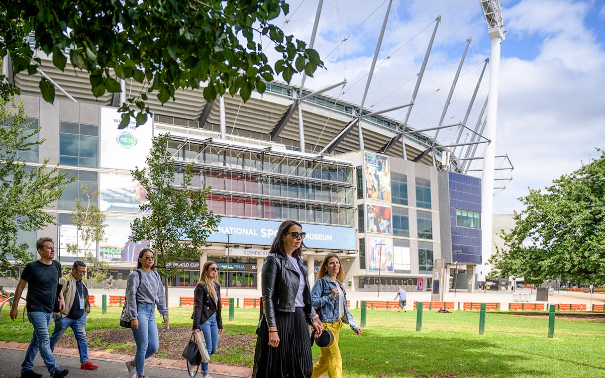 People walking outside Melbourne Cricket Ground on a guided sports tour.