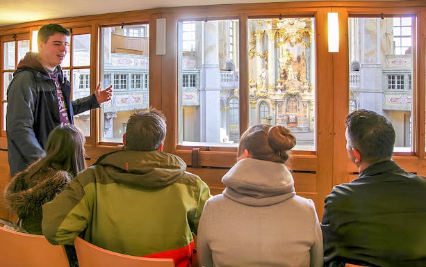 Tour guide explaining Frauenkirche interior to visitors on a gallery tour.