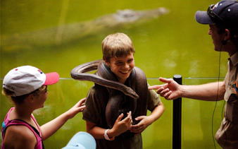 Child holding a snake at Hartley's Crocodile Adventure, Australia.