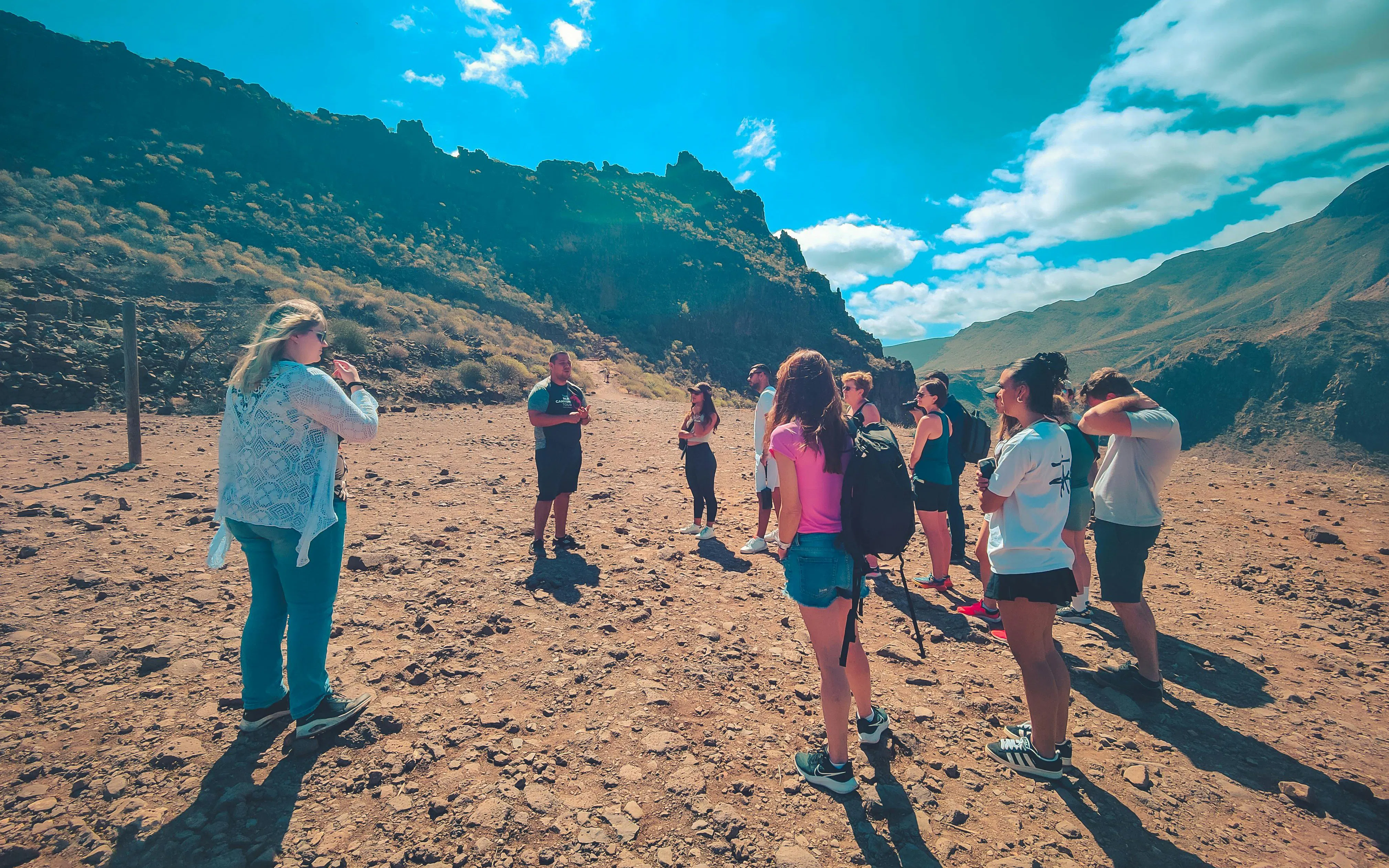 Group of hikers on The Red Canyon Tour exploring rugged landscape in Gran Canaria, Spain.