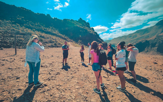 Group of hikers on The Red Canyon Tour exploring rugged landscape in Gran Canaria, Spain.