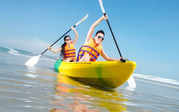 Couple kayaking in Dubai wearing life jackets.