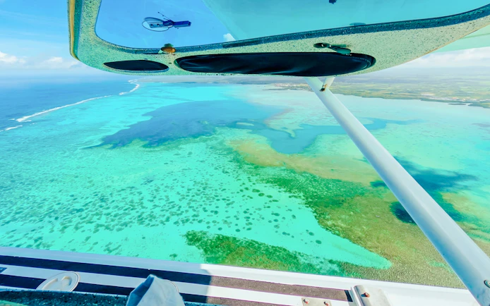 Aerial view of turquoise waters and coral reefs from a seaplane during the Scenic Seaplane Tour, Mauritius.