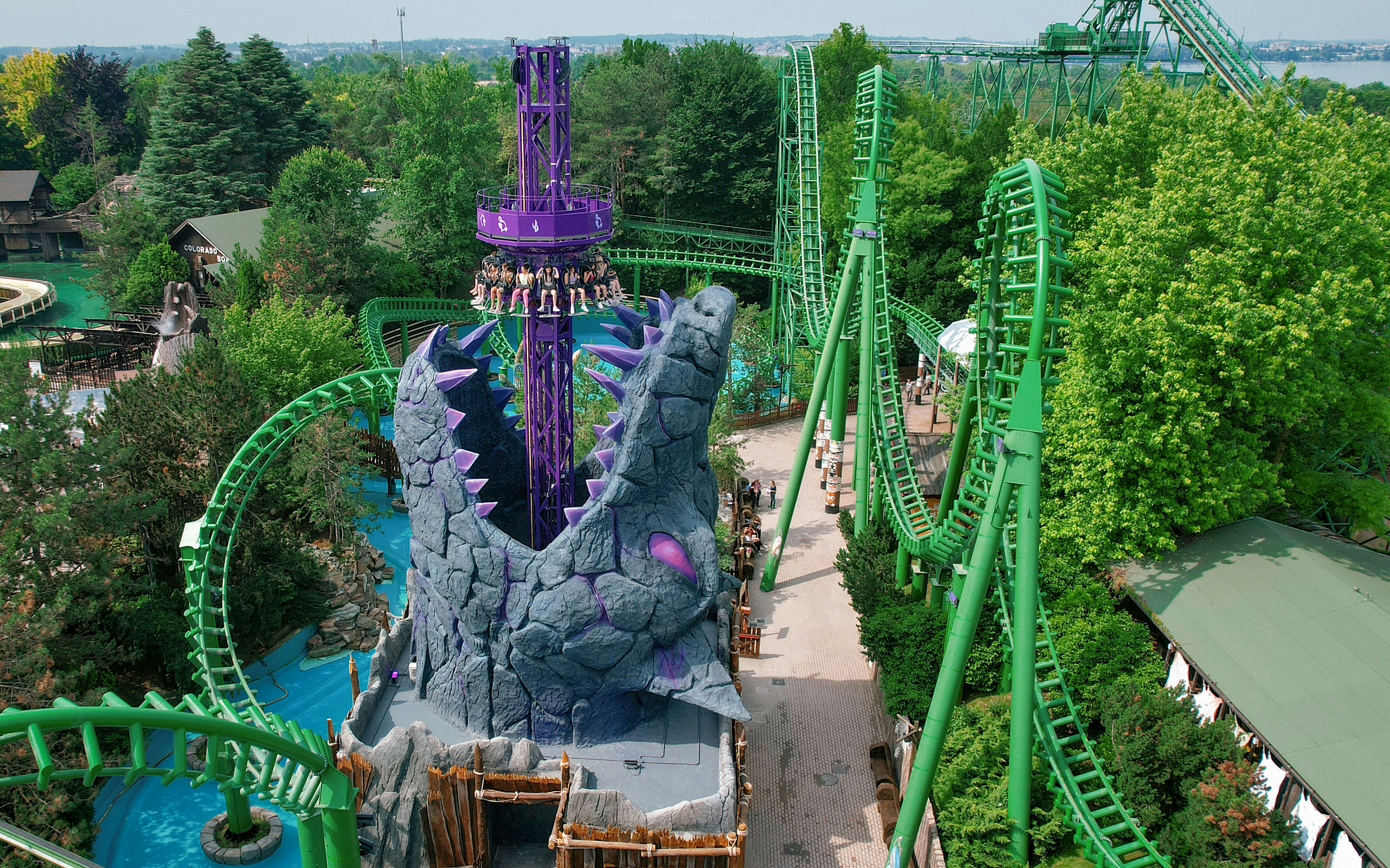 Wolf Legend Ride at Gardaland with towering purple structure and green roller coaster tracks.