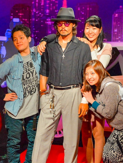 Visitors posing with a wax figure at Madame Tussauds.