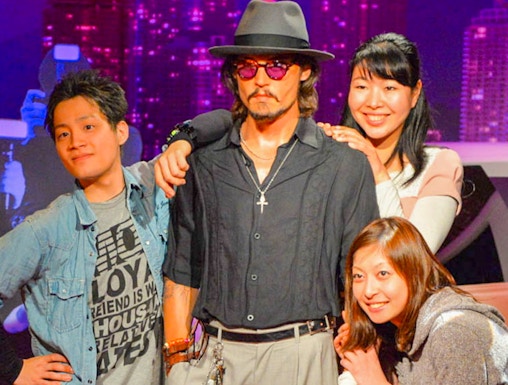 Visitors posing with a wax figure at Madame Tussauds.