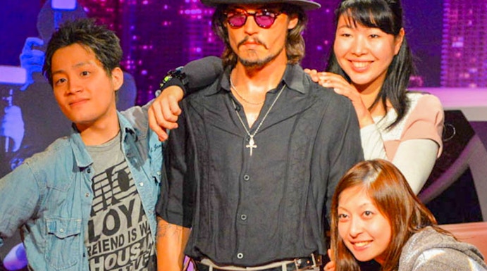 Visitors posing with a wax figure at Madame Tussauds.