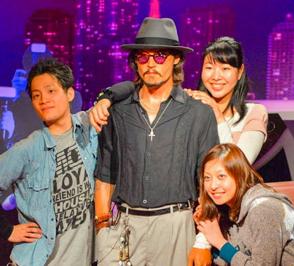 Visitors posing with a wax figure at Madame Tussauds.