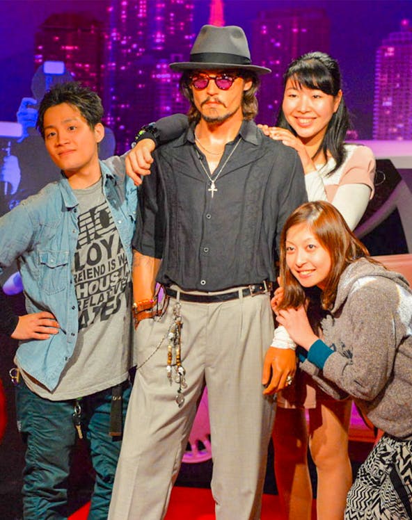 Visitors posing with a wax figure at Madame Tussauds.
