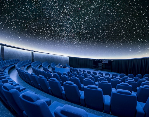 Hemisfèric building in Valencia's City of Arts and Sciences with reflection in water.