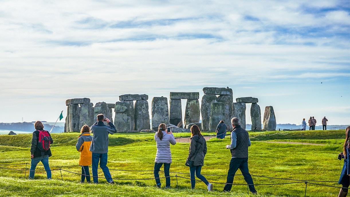 Tourists at Stonehenge, viewing ancient stone structures on a day trip from London.