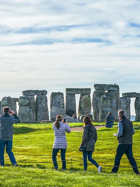 Tourists at Stonehenge, viewing ancient stone structures on a day trip from London.