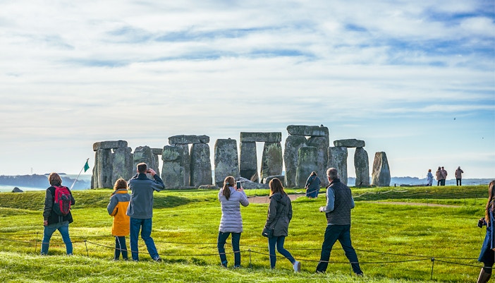 Tourists at Stonehenge, viewing ancient stone structures on a day trip from London.