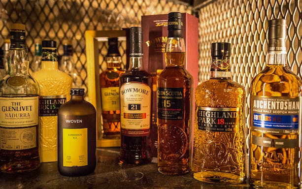 Assorted whiskey bottles for tasting experience.