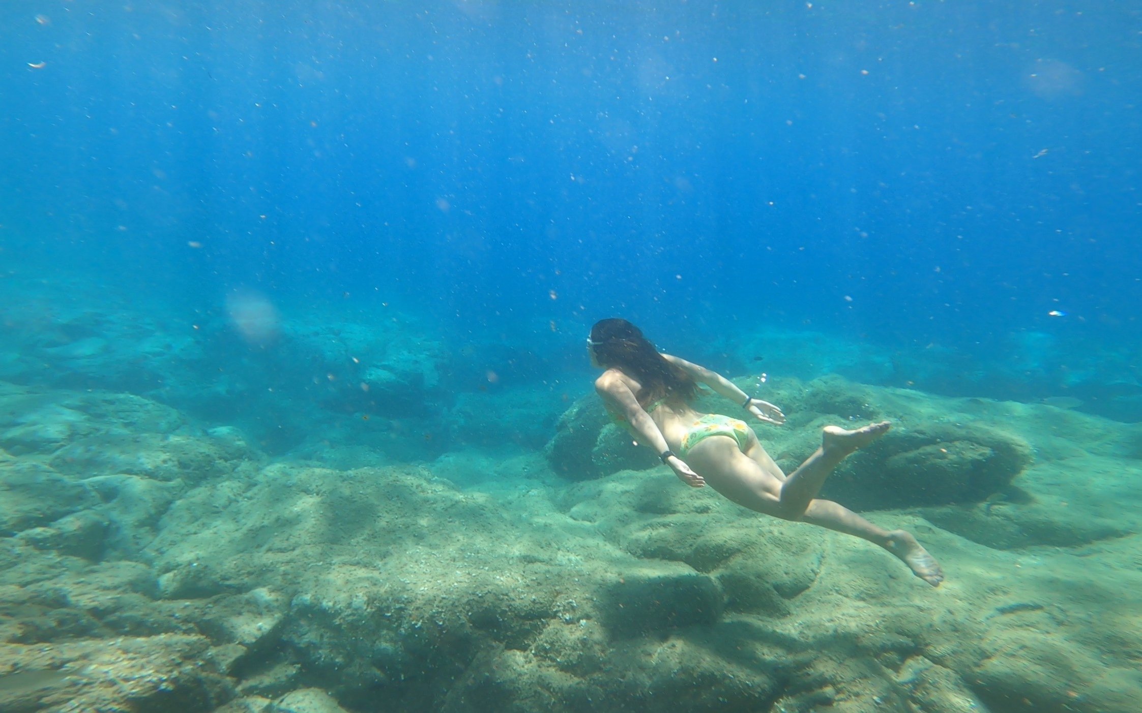 Young woman snorkeling over rocky seabed in Costa Brava.
