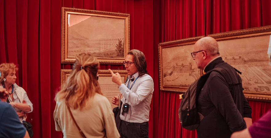 Guide explaining artwork to a small group at Royal Palace of Caserta tour.