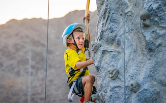 Child climbing rock wall at Fujairah Adventure Park.