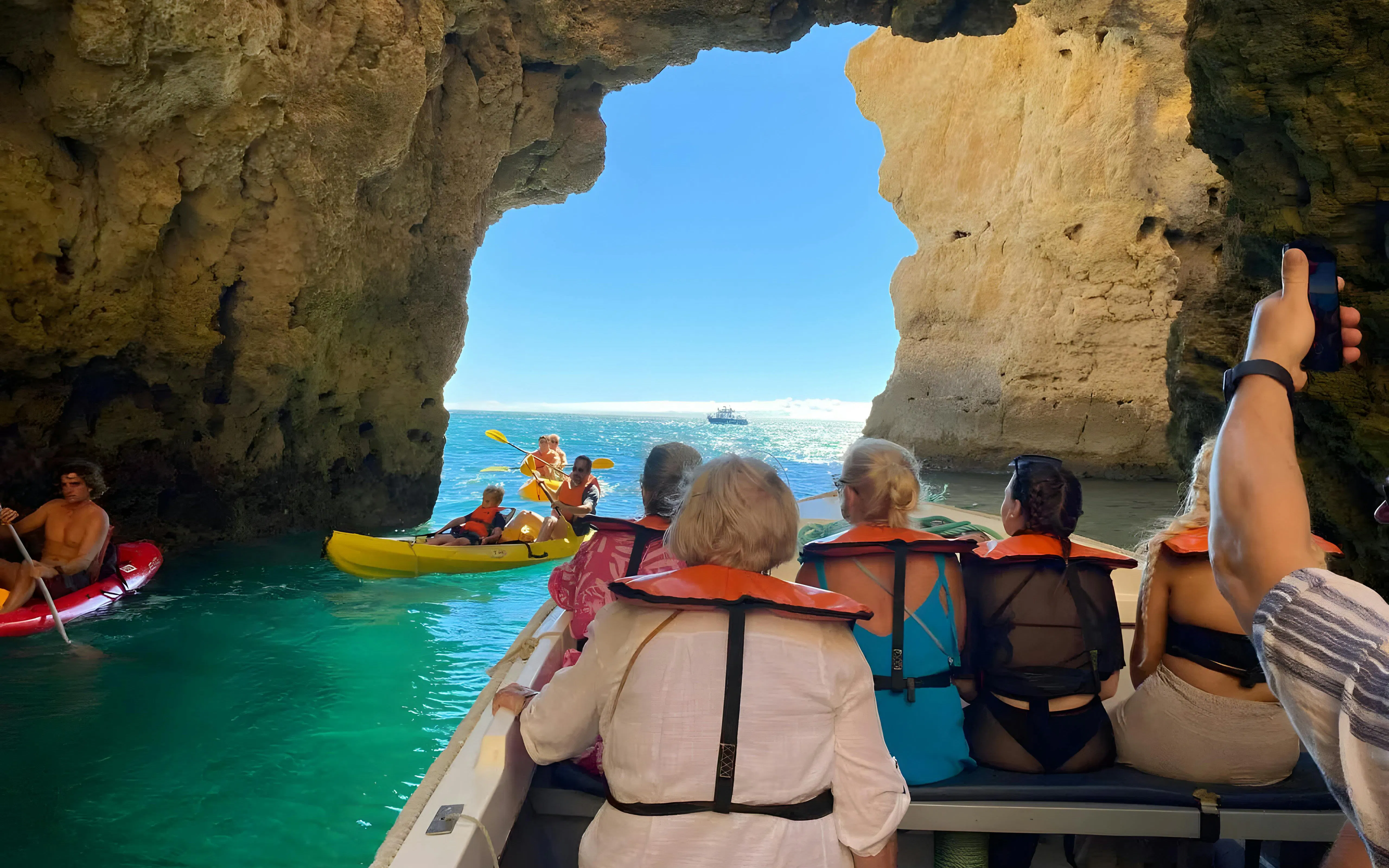 Tourists on a boat exploring Ponta da Piedade caves in Algarve, Portugal.
