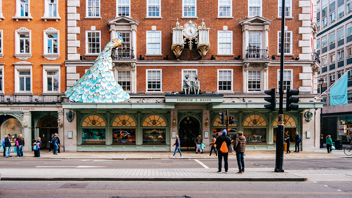 Fortnum & Mason storefront in London with iconic clock and peacock sculpture.