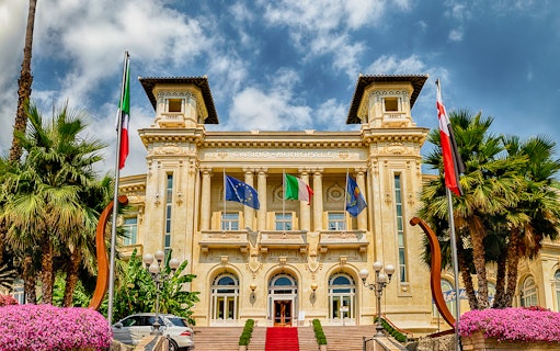 Casino Sanremo facade with flags, Italian Riviera tour.