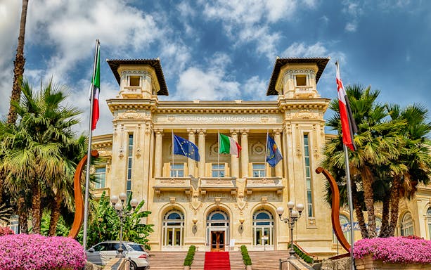 Casino Sanremo facade with flags, Italian Riviera tour.
