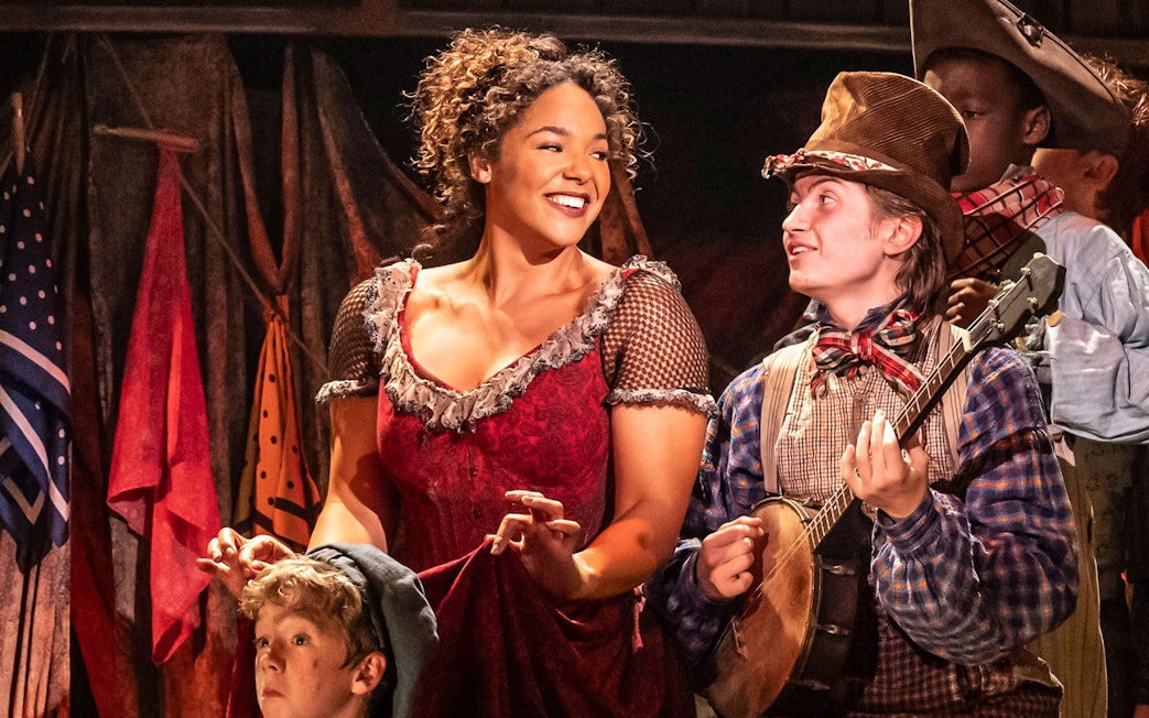 Cast members performing in the musical Oliver! with costumes and props.