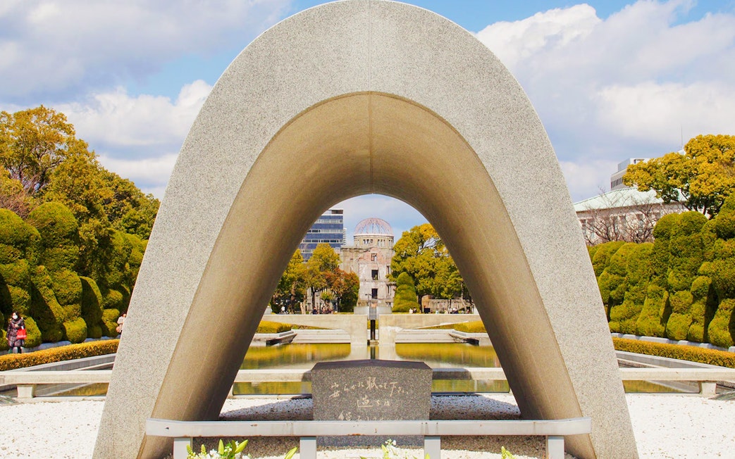 Memorial Cenotaph with Atomic Bomb Dome in Peace Memorial Park, Hiroshima.