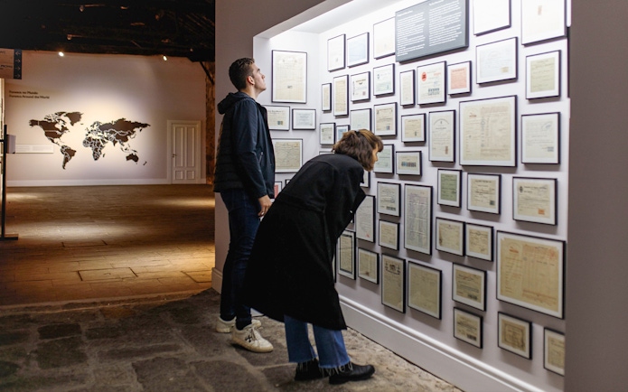Visitors examining historical documents at Fonseca Port Wine Cellars in Portugal.