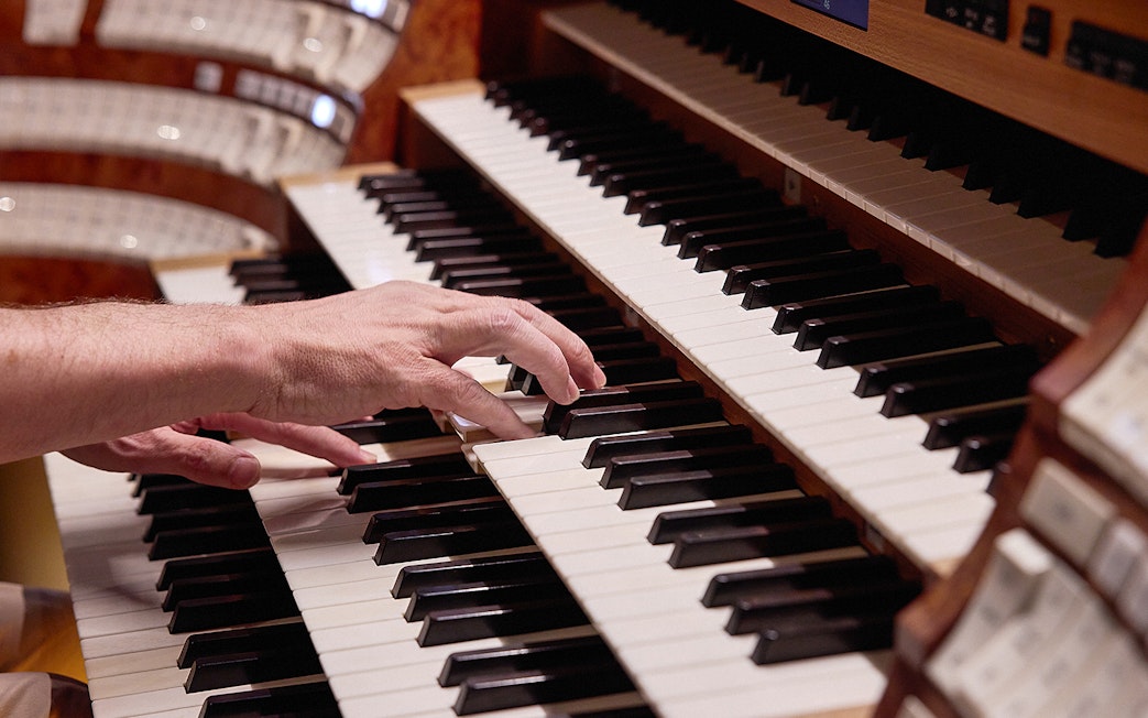 Hands playing organ keys at St. Stephen's Cathedral concert.