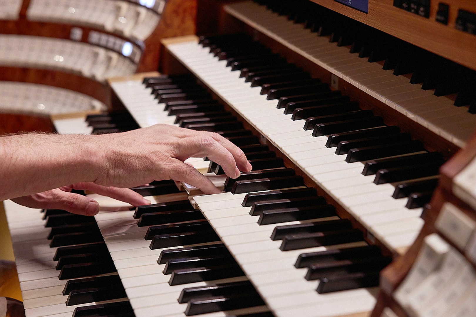 Hands playing organ keys at St. Stephen's Cathedral concert.