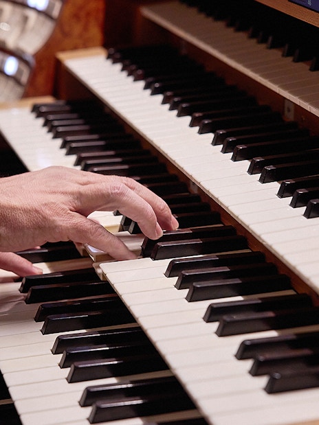 Hands playing organ keys at St. Stephen's Cathedral concert.
