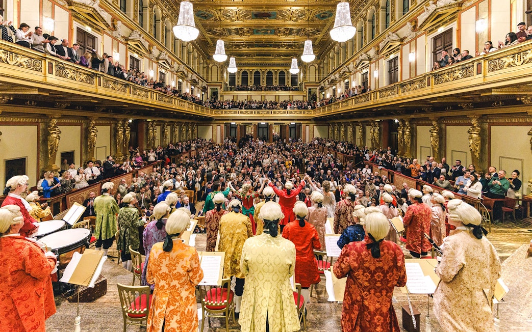 Mozart Orchestra performing in Vienna's Golden Hall at Musikverein, audience applauding.