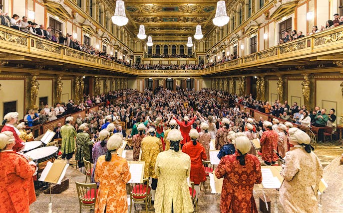 Mozart Orchestra performing in Vienna's Golden Hall at Musikverein, audience applauding.