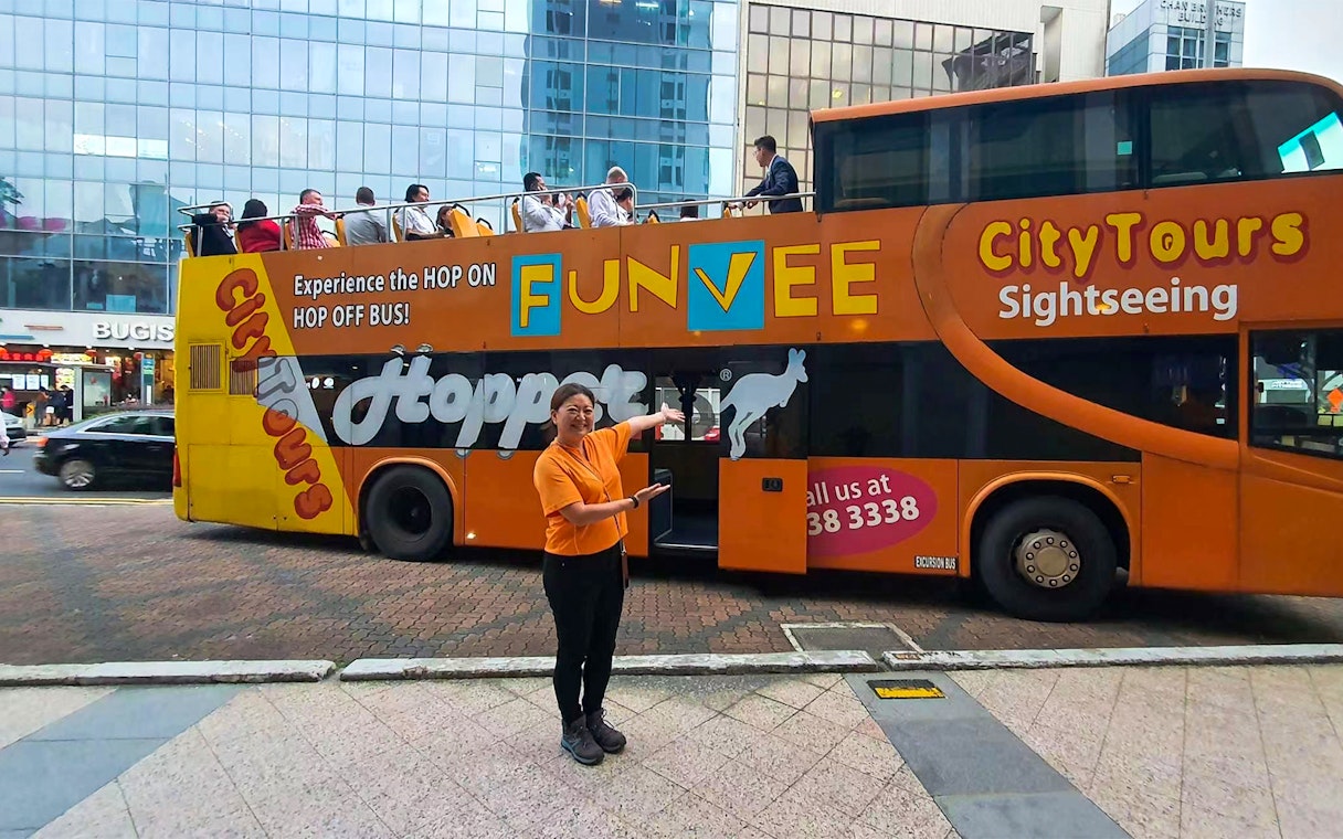 FunVee open-top bus with tourists in Singapore city tour.