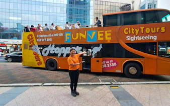 FunVee open-top bus with tourists in Singapore city tour.