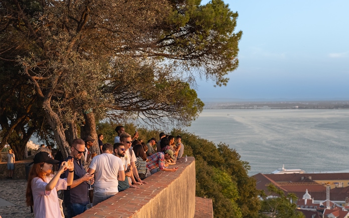 Visitors enjoying the view from St. George’s Castle overlooking Lisbon and the Tagus River.