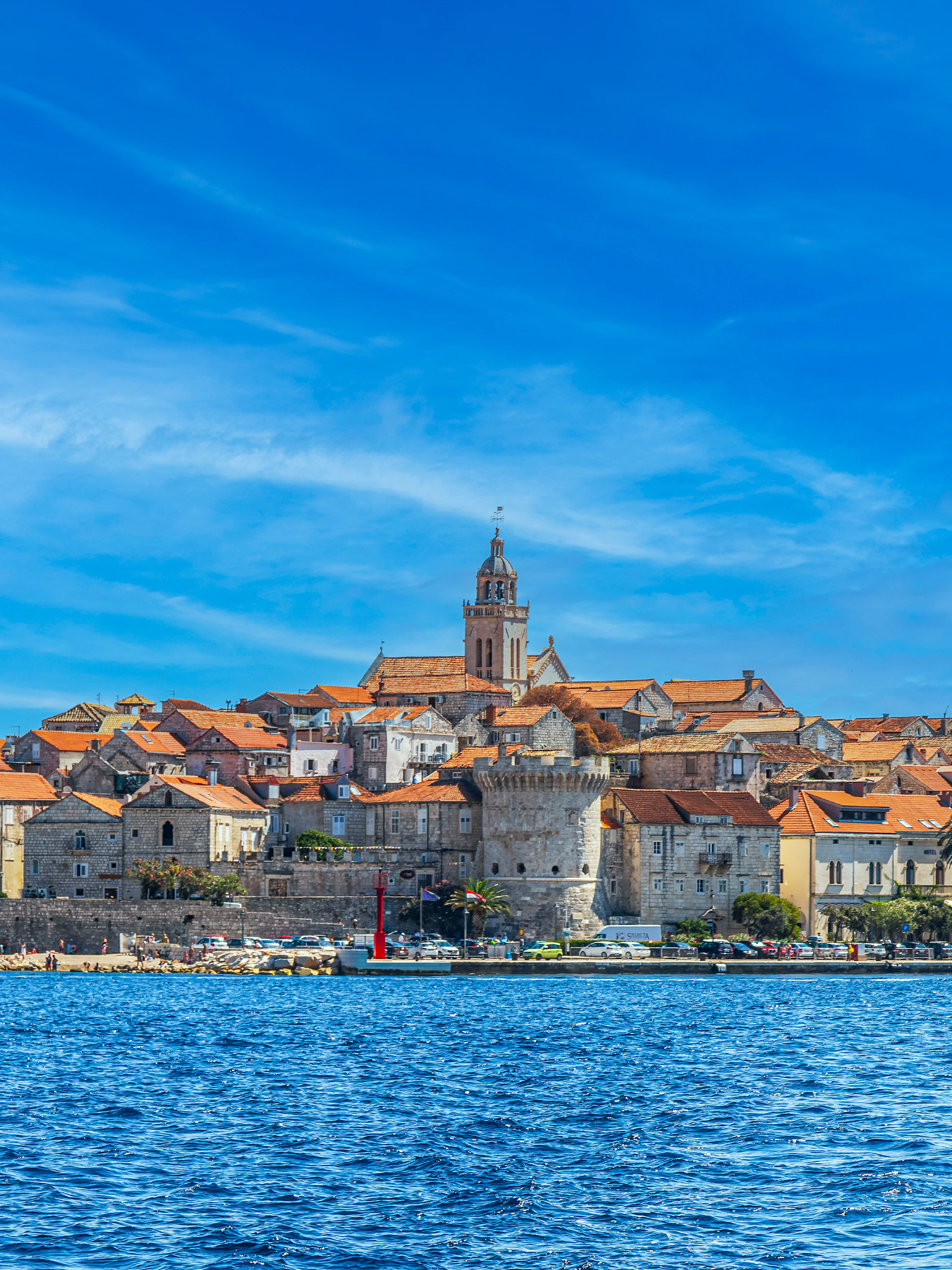 Medieval town of Korcula, Croatia viewed from the sea with historic buildings and church tower.