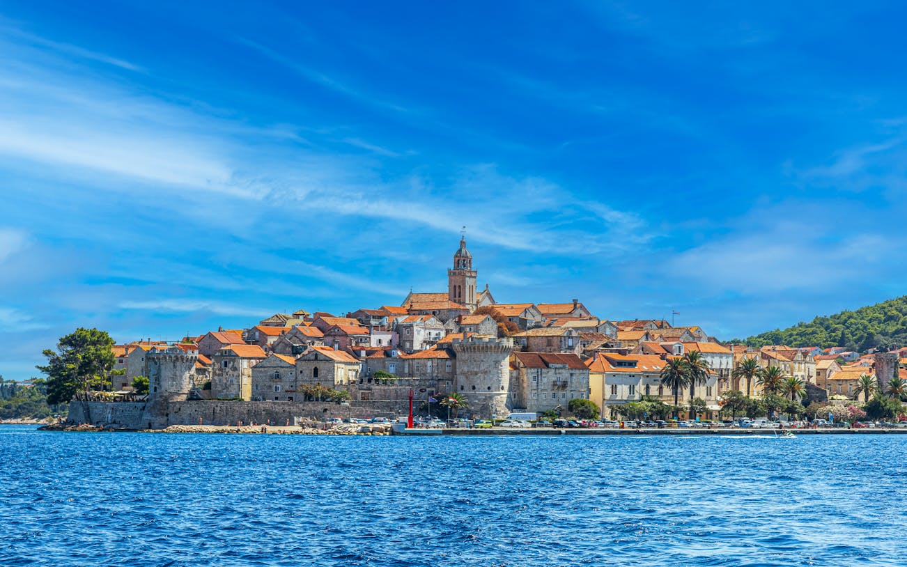 Medieval town of Korcula, Croatia viewed from the sea with historic buildings and church tower.