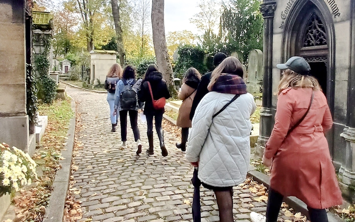Visitors walking through Père Lachaise Cemetery in Paris, France.