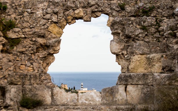 Stone wall with a view of the sea and lighthouse in Colle of Sant'Elia.