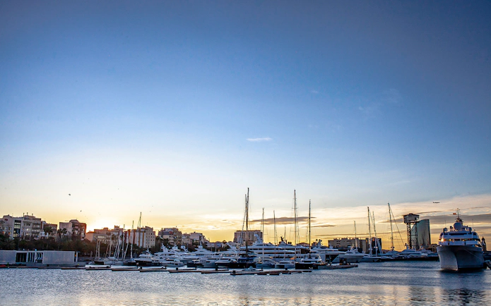 La Barceloneta harbor with yachts at sunset during a 3-hour guided food tour.