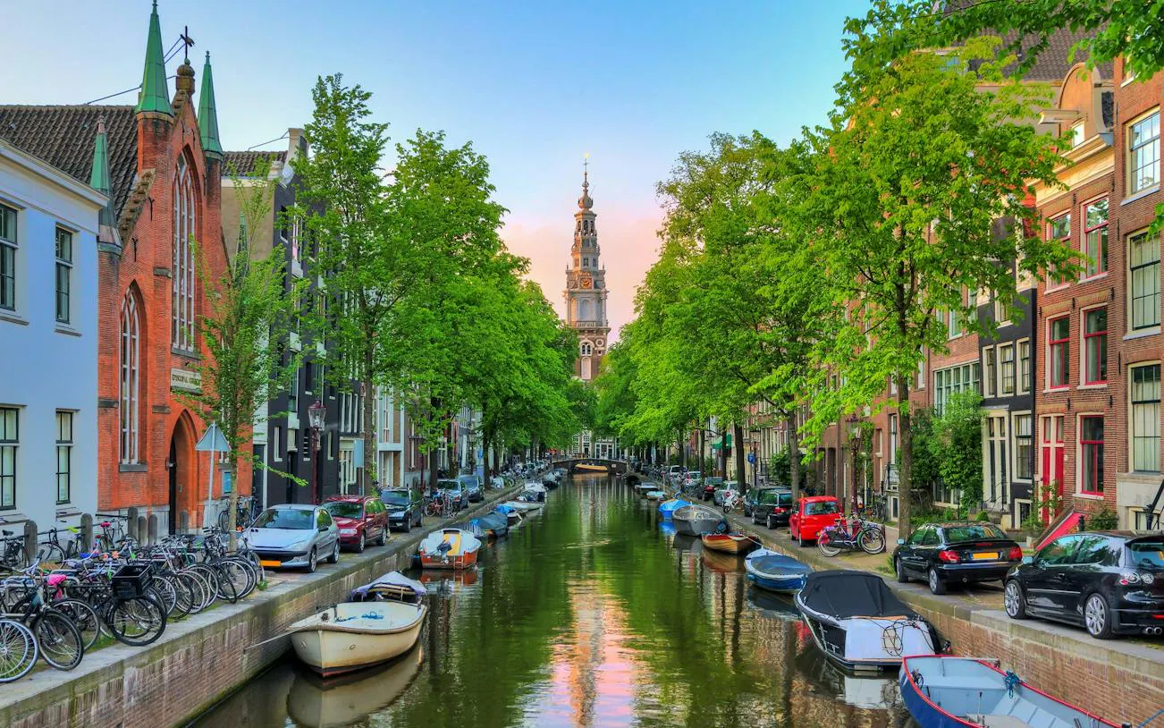 Amsterdam canal with boats, bicycles, and historic buildings in the Jewish Old Quarter.