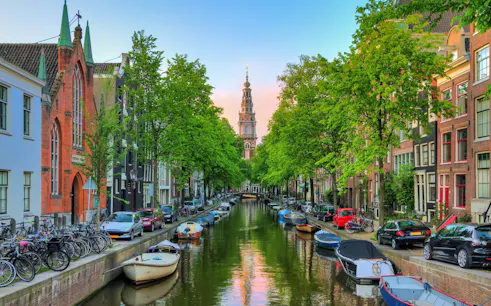 Amsterdam canal with boats, bicycles, and historic buildings in the Jewish Old Quarter.