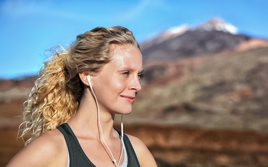 Person with earphones enjoying Mount Vesuvius view in Naples.